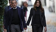 El expresidente francés Nicolas Sarkozy y su esposa Carla Bruni-Sarkozy salen de su casa el martes 21 de octubre de 2025 en París, antes de ingresar en prisión.