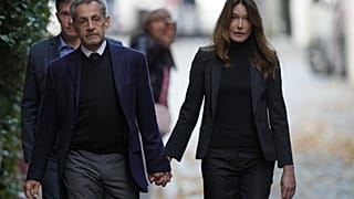 El expresidente francés Nicolas Sarkozy y su esposa Carla Bruni-Sarkozy salen de su casa el martes 21 de octubre de 2025 en París, antes de ingresar en prisión.