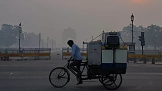 A cyclist pedals through morning smog near the India Gate monument as he transports used home appliances a day after Diwali festival in New Delhi, India.