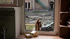 Μια γυναίκα κοιτάζει μια κατεστραμμένη πολυκατοικία μετά από ρωσική επίθεση, την Πέμπτη 23 Οκτωβρίου 2025, στη γειτονιά Podil του Κιέβου, Ουκρανία. 
