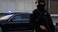 Zamaskowani i uzbrojeni holenderscy policjanci pilnują transportu podejrzanych, którzy przybyli do budynku sądu we wtorek 23 stycznia 2024 roku w Amsterdamie w Holandii
