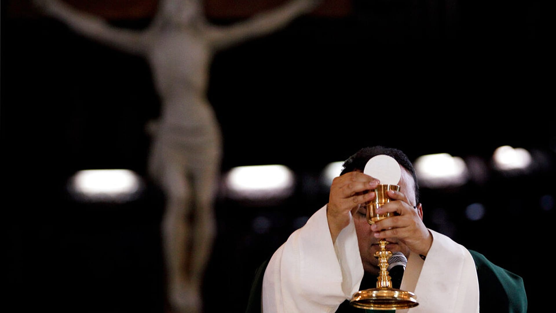 كاهن يبارك  النبيذ والخبز وهو يحتفل بالقداس في كنيسة كاثوليكية في كاراكاس ، فنزويلا.