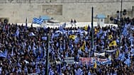 FILE: People with Greek flags attend a rally in front of the Tomb of the Unknown Soldier in Athens, Sunday, Feb. 4, 2018.