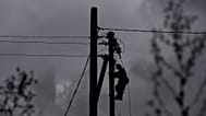 A worker climbs a utility pole while repairing power lines damaged in a Russian attack, Thursday, Oct. 16, 2025, in Shostka, Ukraine. 