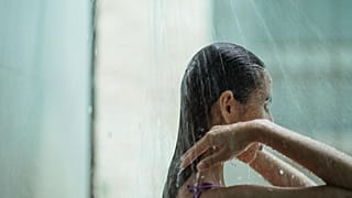 امرأة تستحمّ تحت دُشّ