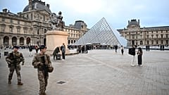 Des soldats patrouillent alors que les gens font la queue pour essayer d'entrer dans le musée du Louvre, bien qu'il reste fermé pour la journée après le vol de bijoux de dimanche, lundi 20 octobre 2025 à Paris. (AP Ph