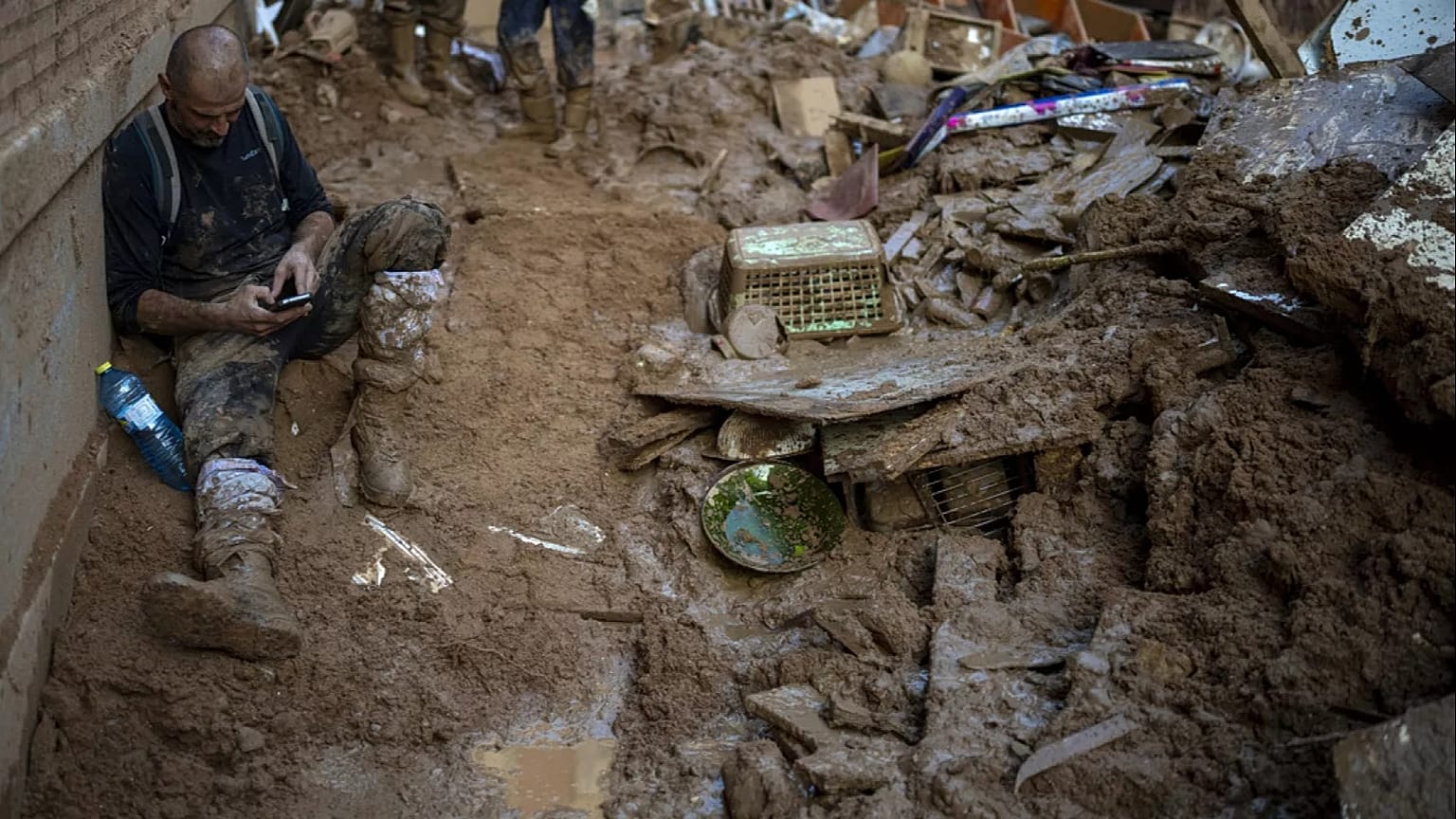 Un voluntario descansa cerca de la casa donde limpia el barro acumulado por las inundaciones, en Masanasa, Valencia, España, el jueves 7 de noviembre de 2024. 
