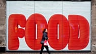 A pedestrian passes a shop hoarding in London, 20 February 2025.