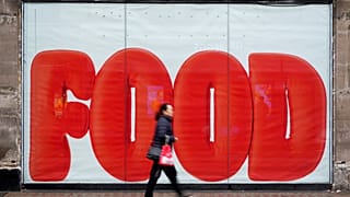 A pedestrian passes a shop hoarding in London, 20 February 2025.