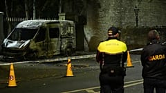 Des officiers de police de la Garda Siochana se tiennent sur les lieux d'un véhicule de police incendié, près de l'hôtel Citywest à Dublin, le mercredi 22 octobre 2025