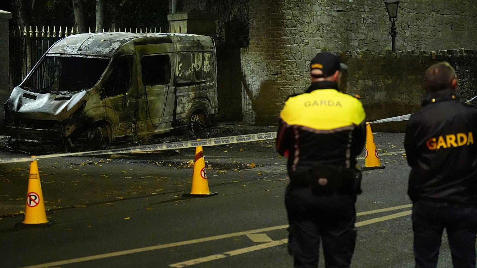 Agenti della Garda Síochána sul luogo in cui un veicolo della polizia è stato bruciato.