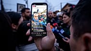 A man films Calin Georgescu, an independent candidate for president who won the first round of presidential elections in Romania.