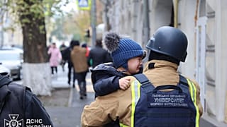Des sauveteurs évacuent des enfants après que des drones russes ont frappé une école maternelle dans la ville de Kharkiv, en Ukraine, le mercredi 22 octobre 2025.