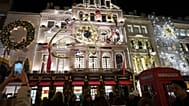 FILE. Pedestrians photograph stores with Christmas lights on Bond Street in London. 19 Dec. 2024.