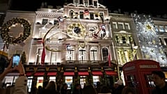 DOSSIER. Des piétons photographient des magasins illuminés sur Bond Street à Londres. 19 décembre 2024.