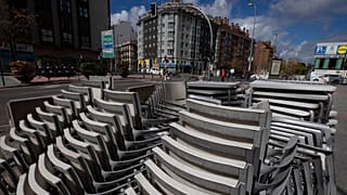 FILE: Chairs and tables sit stacked up outside a closed bar terrace in Madrid, Spain, Tuesday, April 28, 2020.
