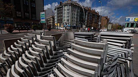 Стулья и столы сложены у террасы бара в Мадриде, архив