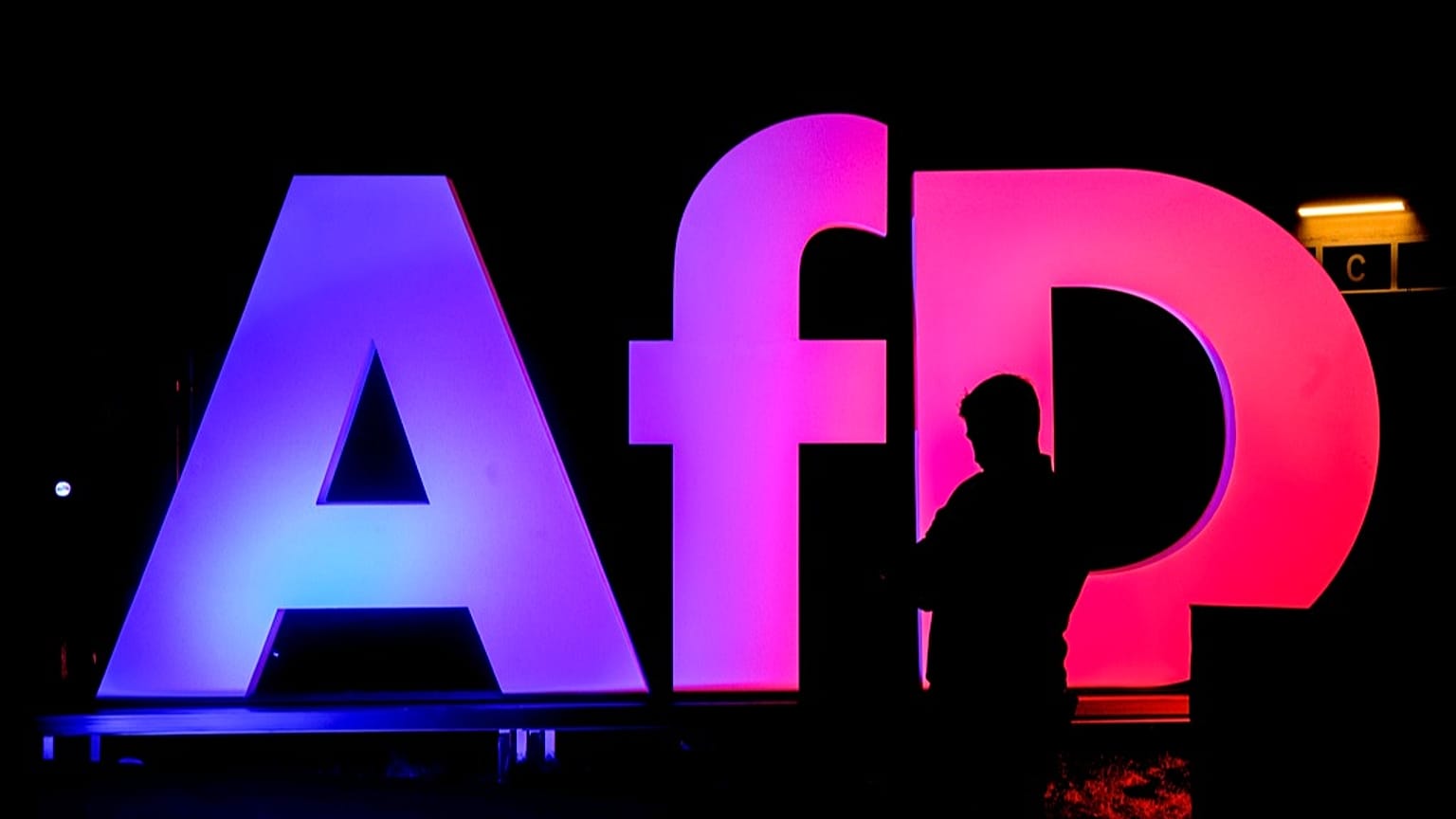DATEI – Ein Mann steht vor dem Logo am Parteizentrum der AfD in Berlin am 23. Februar 2025, nach der Bundestagswahl