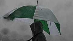 Ein Besucher schützt sich mit einem Regenschirm an einem Aussichtspunkt beim Griffith Park Observatory während eines Sturms am Dienstag, den 14. Oktober 2025, in Los Angeles