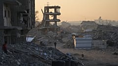 فلسطينيون يسيرون وسط الدمار الذي خلّفته الهجمات الجوية والبرية الإسرائيلية في حي الشيخ رضوان بمدينة غزة، الأربعاء 22 تشرين الأول/أكتوبر 2025. 