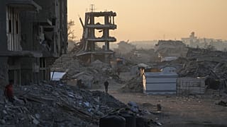فلسطينيون يسيرون وسط الدمار الذي خلّفته الهجمات الجوية والبرية الإسرائيلية في حي الشيخ رضوان بمدينة غزة، الأربعاء 22 تشرين الأول/أكتوبر 2025. 