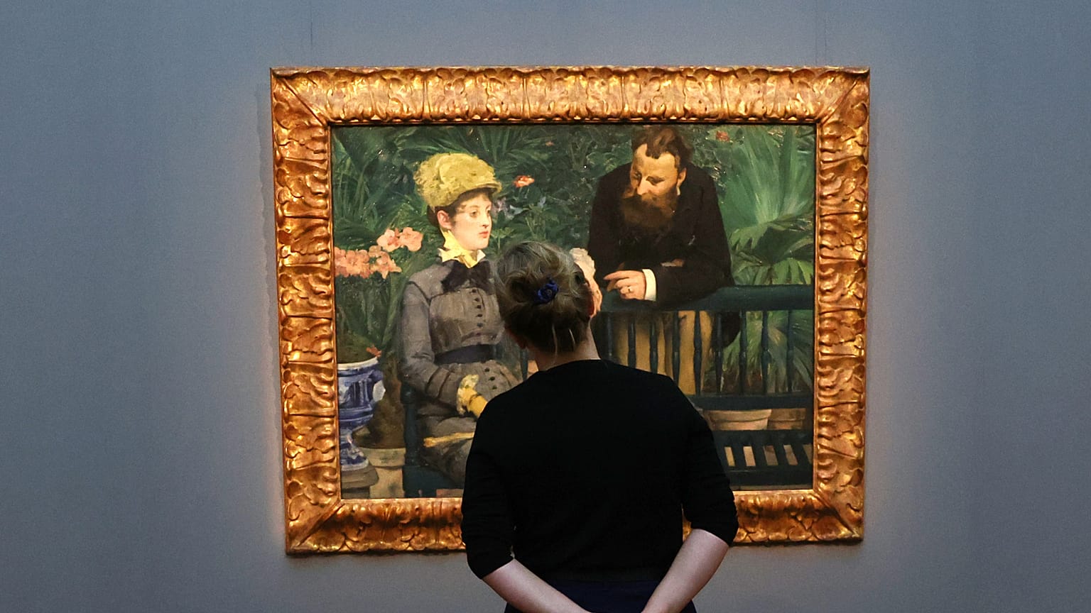 Bir kadın Edouard Manet'nin "Konservatuarda" adlı tablosuna bakıyor