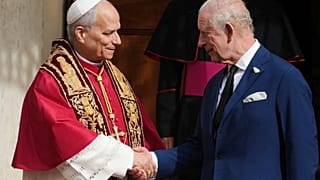 Pope Leo XIV, center, cheers with Britain's King Charles III in the St. Damasus Courtyard at the Vatican