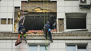 موظفو البلدية يعملون على جانب مبنى سكني متعدد الطوابق تعرض لهجوم بطائرة بدون طيار أوكرانية في كراسنوجورسك، على مشارف موسكو