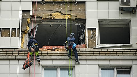 موظفو البلدية يعملون على جانب مبنى سكني متعدد الطوابق تعرض لهجوم بطائرة بدون طيار أوكرانية في كراسنوجورسك، على مشارف موسكو