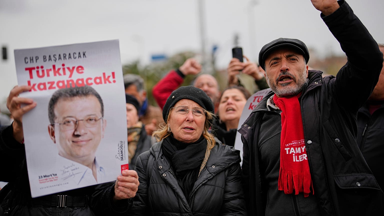 İnsanlar, Ekrem İmamoğlu’nun İstanbul’da gözaltına alındıktan sonra götürüldüğü Vatan Emniyet Müdürlüğü binası önünde İmamoğlu'nun posterlerini taşıyor, 19 Mart 2025
