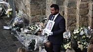 A funeral worker holds a portrait of the 12-year-old schoolgirl, known as Lola, at the end of her funeral ceremony, outside the church of Lillers, northern France in 2022