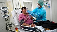 Pfleger Filipe Orfao richtet einem Patienten die Sauerstoffmaske zurecht. Auf der Lungenstation des Lissabonner Hauptkrankenhauses Santa Maria.