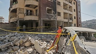  طفل يقف أمام مبنى متضرر تعرض لقصف جوي إسرائيلي مساء الاثنين في بلدة النبطية، جنوب لبنان، الثلاثاء 16 سبتمبر/أيلول 2025. 
