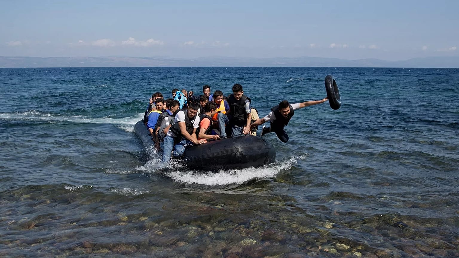 Migrantes afegãos chegam à costa da ilha grega de Lesbos depois de atravessarem o mar Egeu vindos da Turquia num bote insuflável, 25 de setembro de 2015