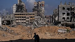 فلسطينيون يسيرون وسط الدمار الذي خلفته الغارات الجوية والأرضية الإسرائيلية في مخيم الشاطئ في مدينة غزة، الجمعة 24 أكتوبر/تشرين الأول 2025.