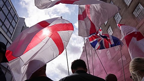 صورة تعبيرية لمتظاهرين يحملون أعلام إنجلترا والعلم البريطاني خلال مسيرة وتجمع حاشد بقيادة تومي روبنسون تحت شعار "توحيد المملكة" في لندن