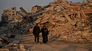 فلسطينيون يسيرون في حوض الدمار الناجم عن الهجوم الجوي والبري الإسرائيلي في مدينة غزة, الخميس, أكتوبر. 23, 2025.