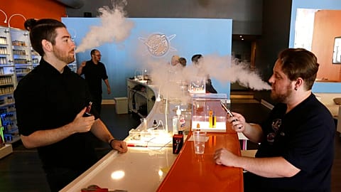 أشخاص يدخنون السجائر الالكترونية