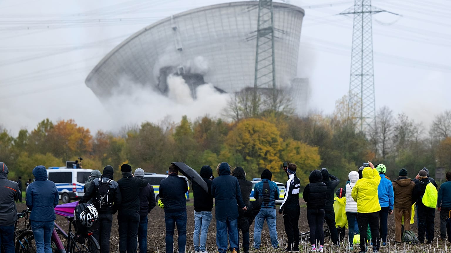Des personnes assistent à l'effondrement de la deuxième tour de refroidissement de la centrale nucléaire désaffectée de Gundremmingen après son démolition à l'explosif.