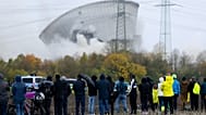 Des personnes assistent à l'effondrement de la deuxième tour de refroidissement de la centrale nucléaire désaffectée de Gundremmingen après son démolition à l'explosif.