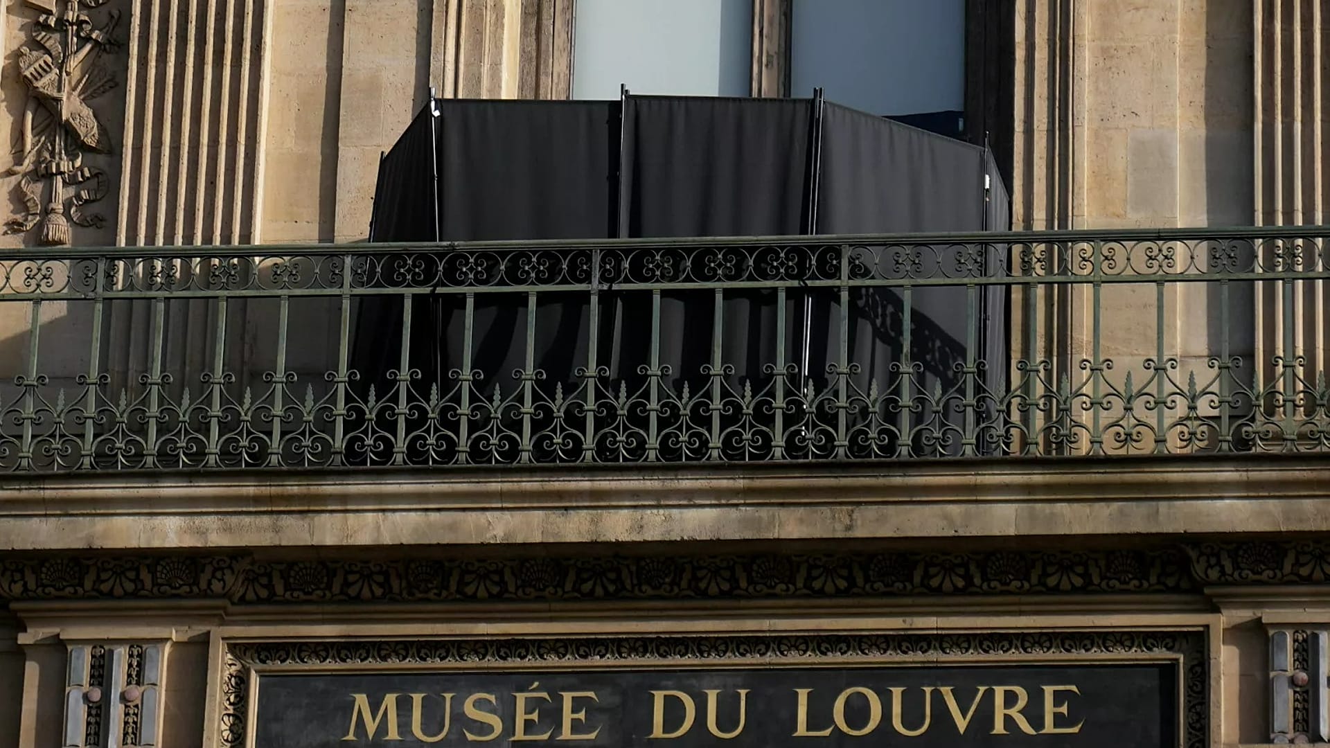 Un rideau noir cache la fenêtre par laquelle les voleurs sont entrés dans le musée du Louvre, le 22 octobre 2025 à Paris.