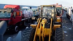 Bulldozer und Lastwagen stehen am Sonntag, 26. Oktober 2025, vor dem ägyptischen Tor des Grenzübergangs Rafah an, um in den Gazastreifen zu gelangen.