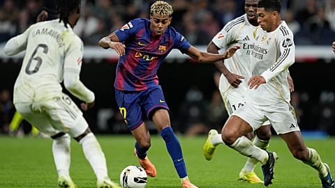 Yamal, del Barcelona, en acción entre Camavinga, del Real Madrid, a la izquierda, y Bellingham, durante el Clásico de fútbol de La Liga el 26 de octubre de 2025.