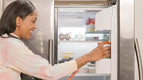 امرأة تضع طعاماً في الثلاجة