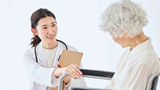 طبيبة تقدم الرعاية والدعم لسيدة مسنّة.