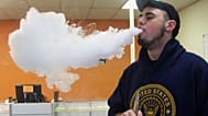 ينفث جوشوا بيلاتز سحابة من البخار بعد استنشاقه من سيجارته الإلكترونية، داخل متجر "Vapors" في دانفيل، إلينوي، 3 نيسان/أبريل 2014.