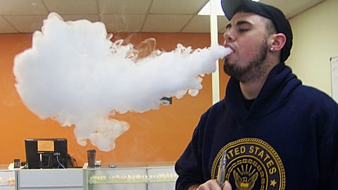 ينفث جوشوا بيلاتز سحابة من البخار بعد استنشاقه من سيجارته الإلكترونية، داخل متجر "Vapors" في دانفيل، إلينوي، 3 نيسان/أبريل 2014.