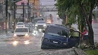 Menschen verlassen ihre Autos wegen der durch Melissa verursachten Überschwemmungen in Santo Domingo, Dominikanische Republik, 24. Oktober 2025 