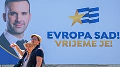 ARŞİV - Karadağ'ın başkenti Podgorica'da insanlar, Europe Now hareketinin lideri Milojko Spajic'in yer aldığı reklam panosunun önünde, 9 Haziran 2023.