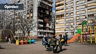 FILE: Children play in a playground in front of missile-damaged buildings ahead of a visit by Ukrainian President Volodymyr Zelenskyy in Zaporizhzhia, 27 March 2023